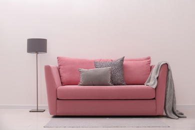 Simple room interior with comfortable pink sofa
