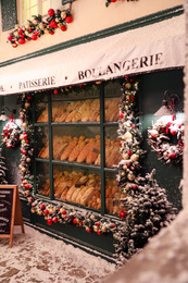 Photo of Bakery shop decorated with Christmas garland outdoors