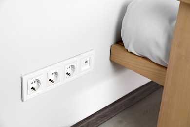 Power sockets on white wall indoors. Electrical supply