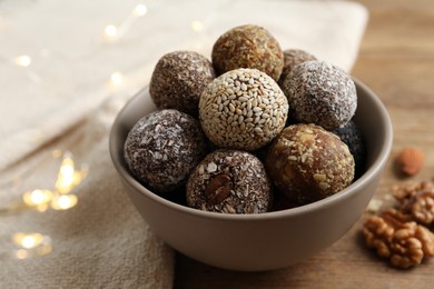 Different delicious vegan candy balls on wooden table, closeup