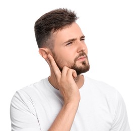Young man suffering from ear pain on white background