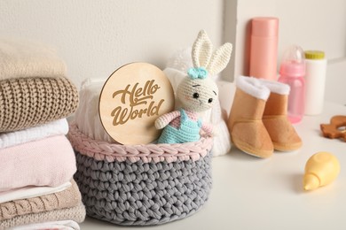 Photo of Baby clothes, toy and accessories on white table
