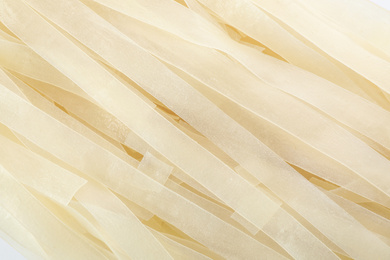 Raw rice noodles as background, closeup view
