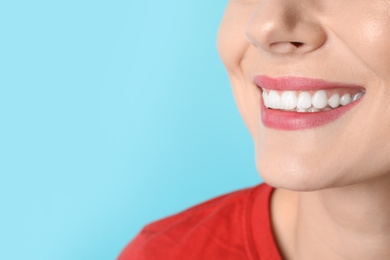 Smiling woman with perfect teeth on color background, closeup. Space for text