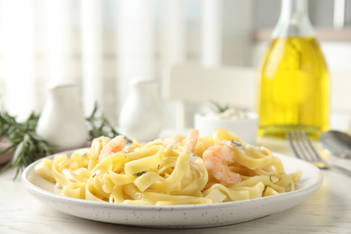 Delicious pasta with shrimps on white wooden table