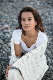 Portrait of happy young woman on pebble beach