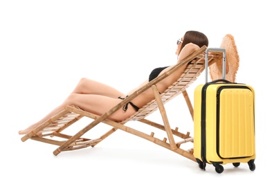 Photo of Young woman with suitcase on sun lounger against white background. Beach accessories
