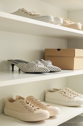 Photo of Storage rack with stylish women's shoes indoors