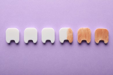 Clean and dirty plastic teeth on violet background, flat lay