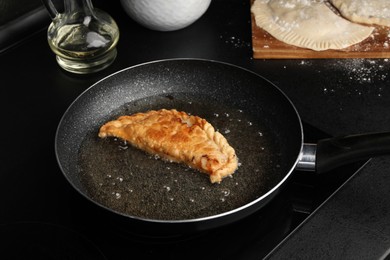 Photo of Cooking chebureki with tasty filling in frying pan
