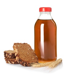 Photo of Glass bottle of delicious kvass, spikelets and bread slices on white background. Refreshing drink