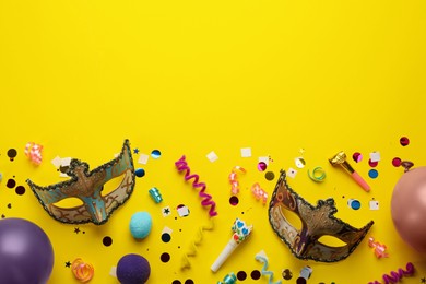 Flat lay composition with carnival items on yellow background. Space for text