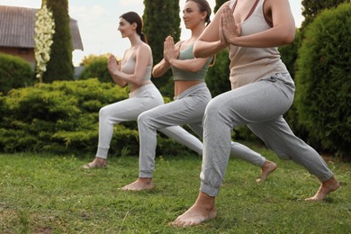 Group of young women practicing yoga outdoors, closeup