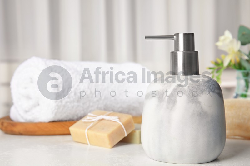 Soap dispenser and toiletries on white table