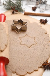 Photo of Homemade Christmas biscuits. Dough, rolling pin and cookie cutter on table, closeup