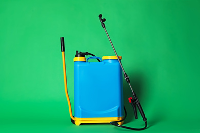 Manual insecticide sprayer on green background. Pest control