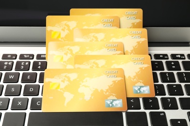 Many golden credit cards on laptop, closeup