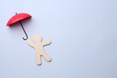 Mini umbrella and human figure on white background, top view. Space for text
