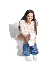 Woman with stomach ache sitting on toilet bowl, white background