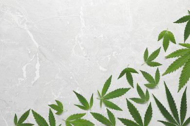 Fresh green hemp leaves on marble table, flat lay. Space for text