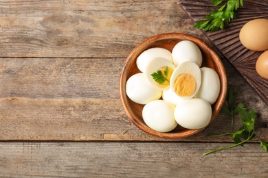 Flat lay composition with boiled eggs and space for text on wooden background