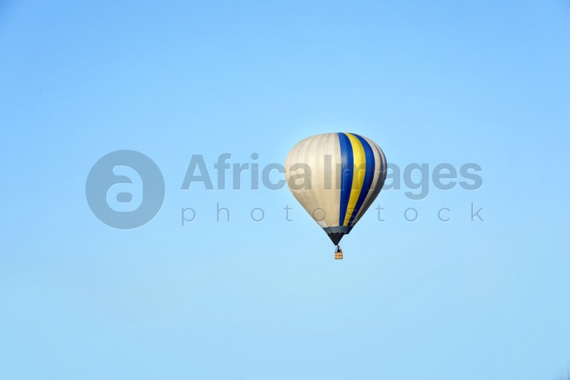 Beautiful view of hot air balloon in blue sky. Space for text