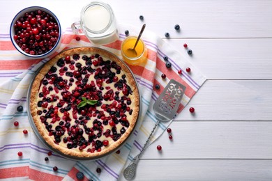 Delicious currant pie and fresh berries on white wooden table, flat lay. Space for text