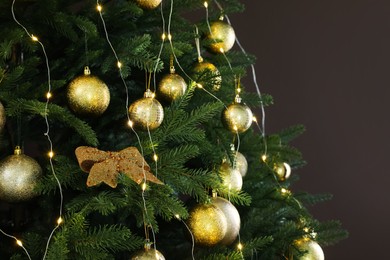 Beautifully decorated Christmas tree on brown background, closeup