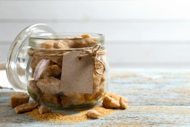 Photo of Glass jar with chunks of brown sugar on rustic table, space for text
