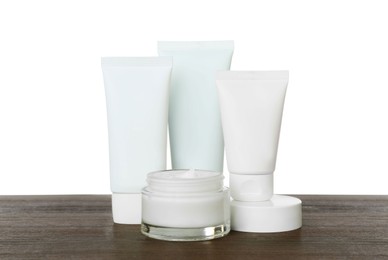Set of cosmetic products in jar and tubes on wooden table against white background