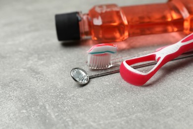 Composition with tongue cleaner and teeth care products on grey table, closeup. Space for text