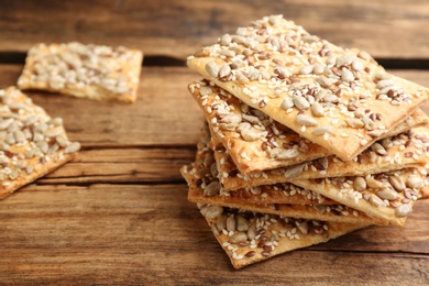 Stack of delicious crackers on wooden table, closeup