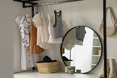 Storage rack with stylish women's clothes and accessories indoors
