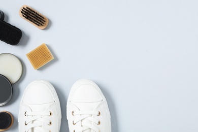 Flat lay composition with stylish footwear and shoe care accessories on white background, space for text