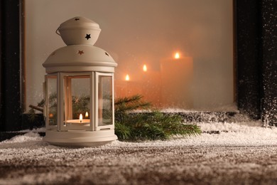 Lantern with candle and fir branches on snowed window sill outdoors, space for text. Christmas Eve