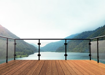 Image of Outdoor wooden terrace revealing picturesque view on lake between mountains