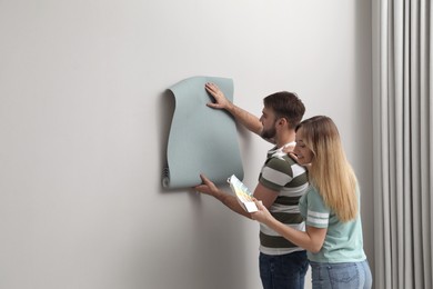 Young couple with new wall paper and color palette  indoors