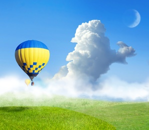 Fantastic dreams. Hot air balloons in blue sky with clouds and crescent moon over misty green meadow
