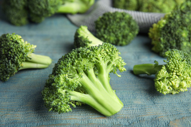 Fresh green broccoli on blue wooden table, closeup
