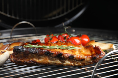 Delicious ribs with rosemary on barbecue grill, closeup
