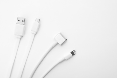 Charge cables on white background, top view. Modern technology