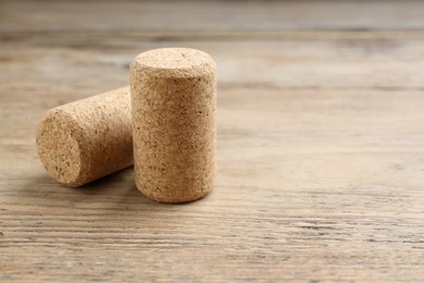 Corks of wine bottles on wooden table, closeup. Space for text