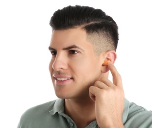Man inserting foam ear plug on white background