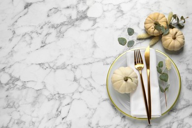 Festive table setting with autumn decor on white marble background, flat lay. Space for text