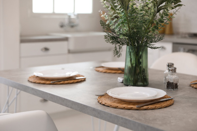 Elegant table setting with ceramic plates in kitchen. Interior design