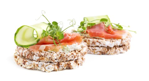 Crunchy buckwheat cakes with cream cheese, prosciutto and cucumber slices on white background