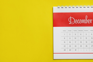 December calendar on yellow background, top view. Space for text