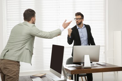 Photo of Emotional colleagues arguing in office. Toxic work environment