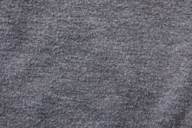 Photo of Grey cloth with lint as background, closeup. Before using of fabric shaver