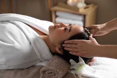 Beautiful Asian woman getting head massage in spa salon